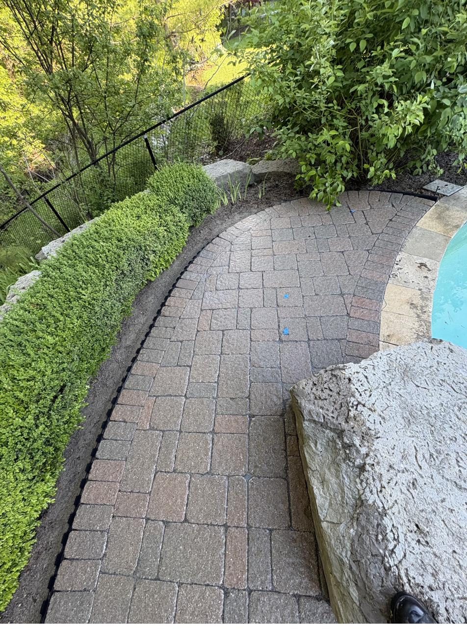 Curved interlock path beside a pool — Pearl Improvements