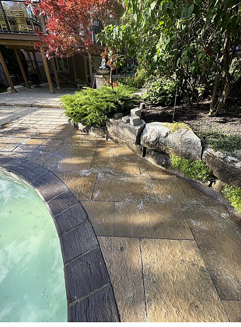 Poolside stone patio by Pearl Improvements