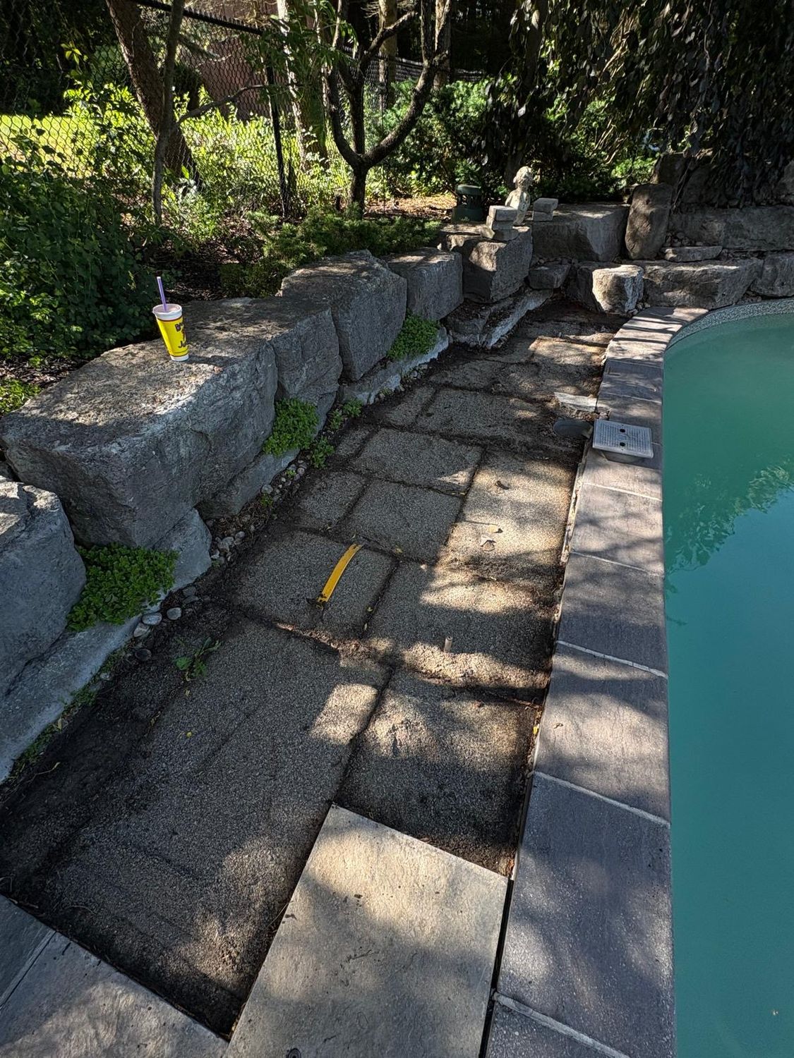 Pool-side slabs before restoration — settled and weathered